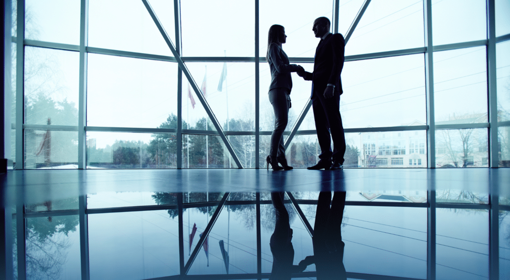 wo professionals shaking hands in a government building, symbolizing trusted federal contracting relationships