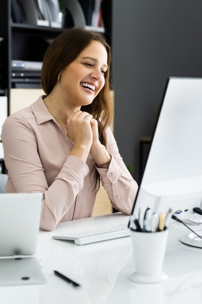 Professional woman smiling during a Zoom call — representing a Federal Business Breakthrough Session with Summit Insight