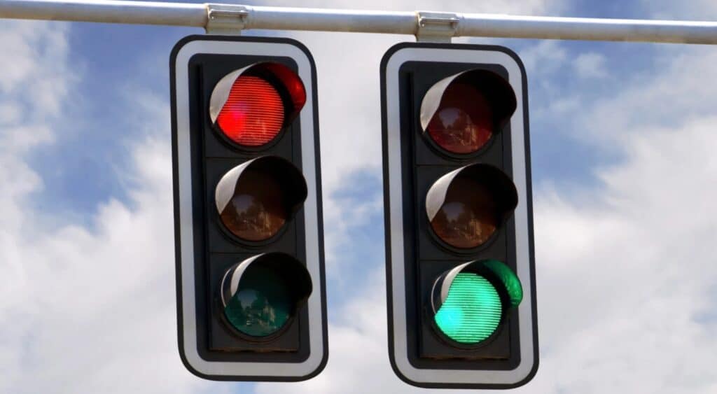 Traffic lights showing a green signal in one lane and a red signal in another, illustrating mixed signals and false permission