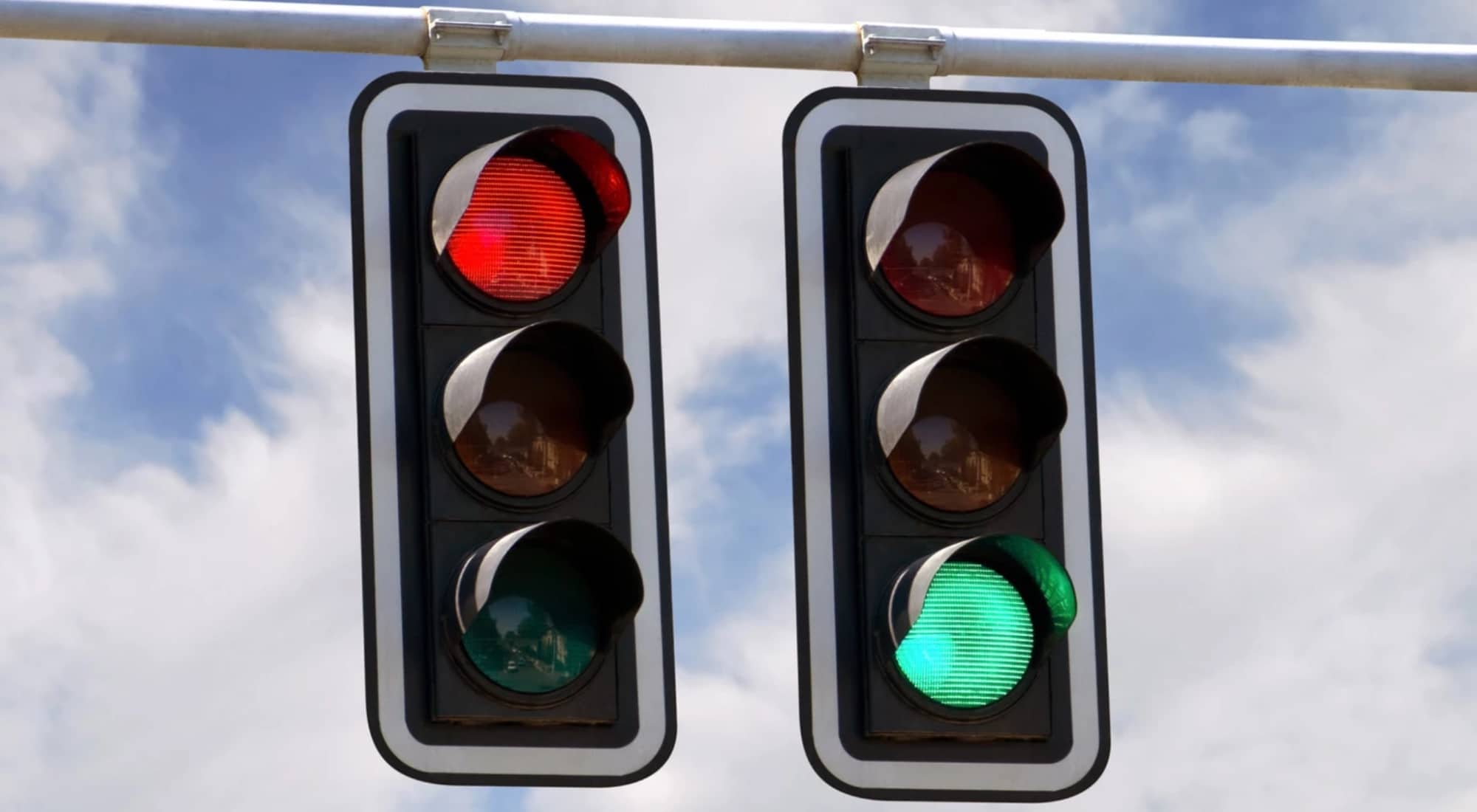 Traffic lights showing a green signal in one lane and a red signal in another, illustrating mixed signals and false permission
